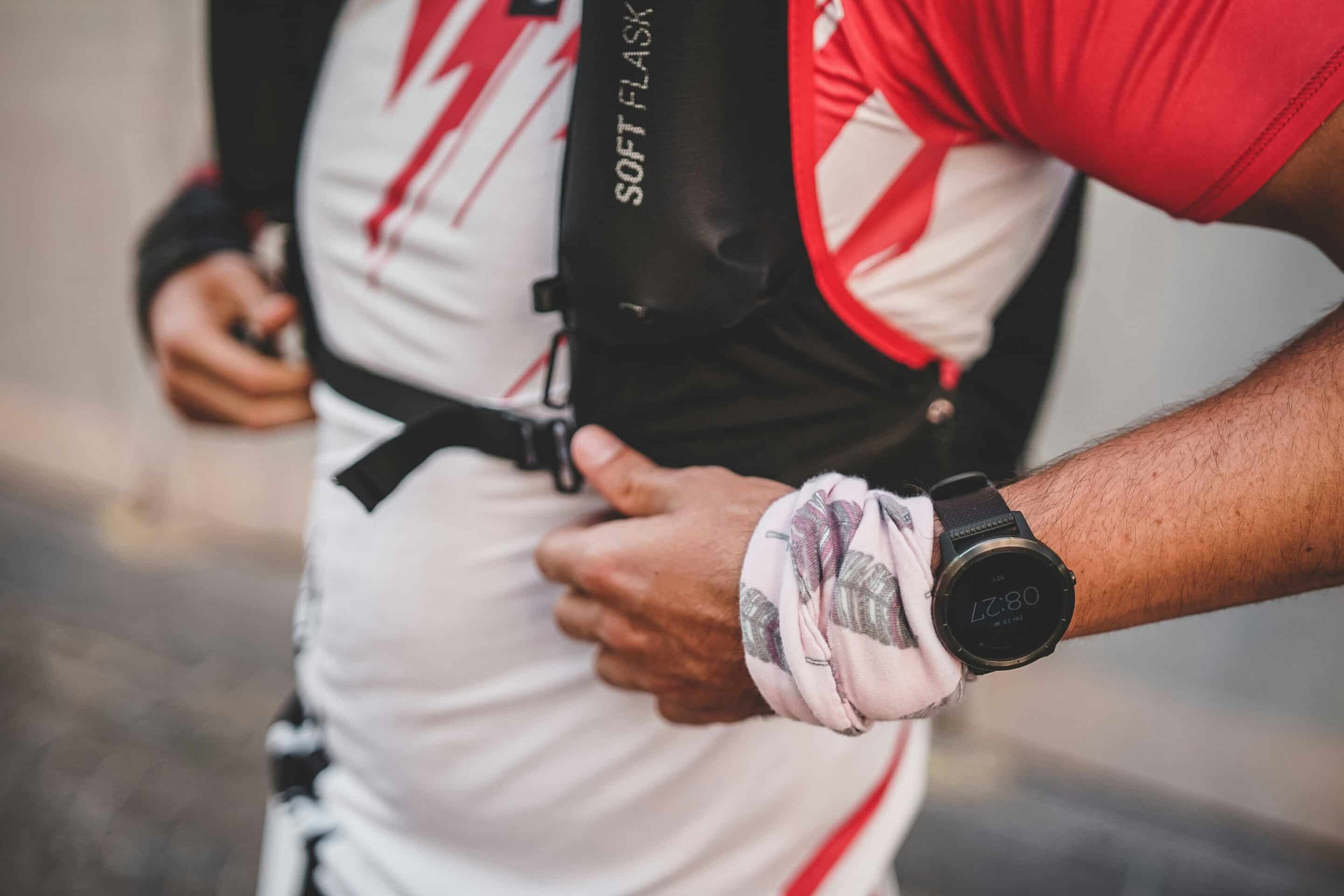 close up of person in a running vest and watch buckling the vest.