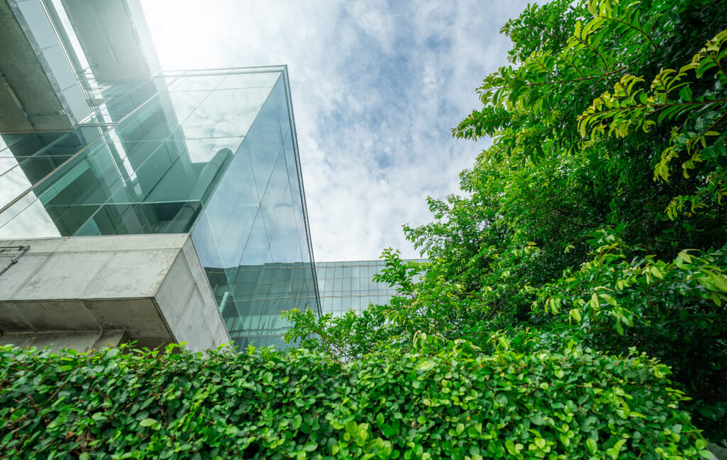 Modern commercial building shot from below with trees on the right side