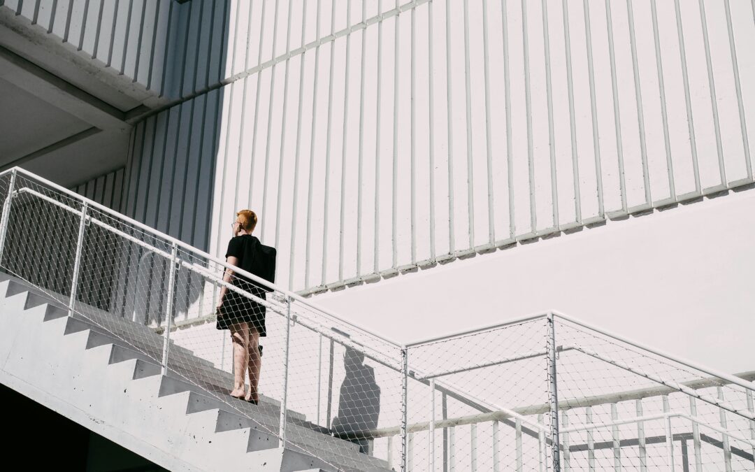 side view of white commercial building with man walking up the stairs.