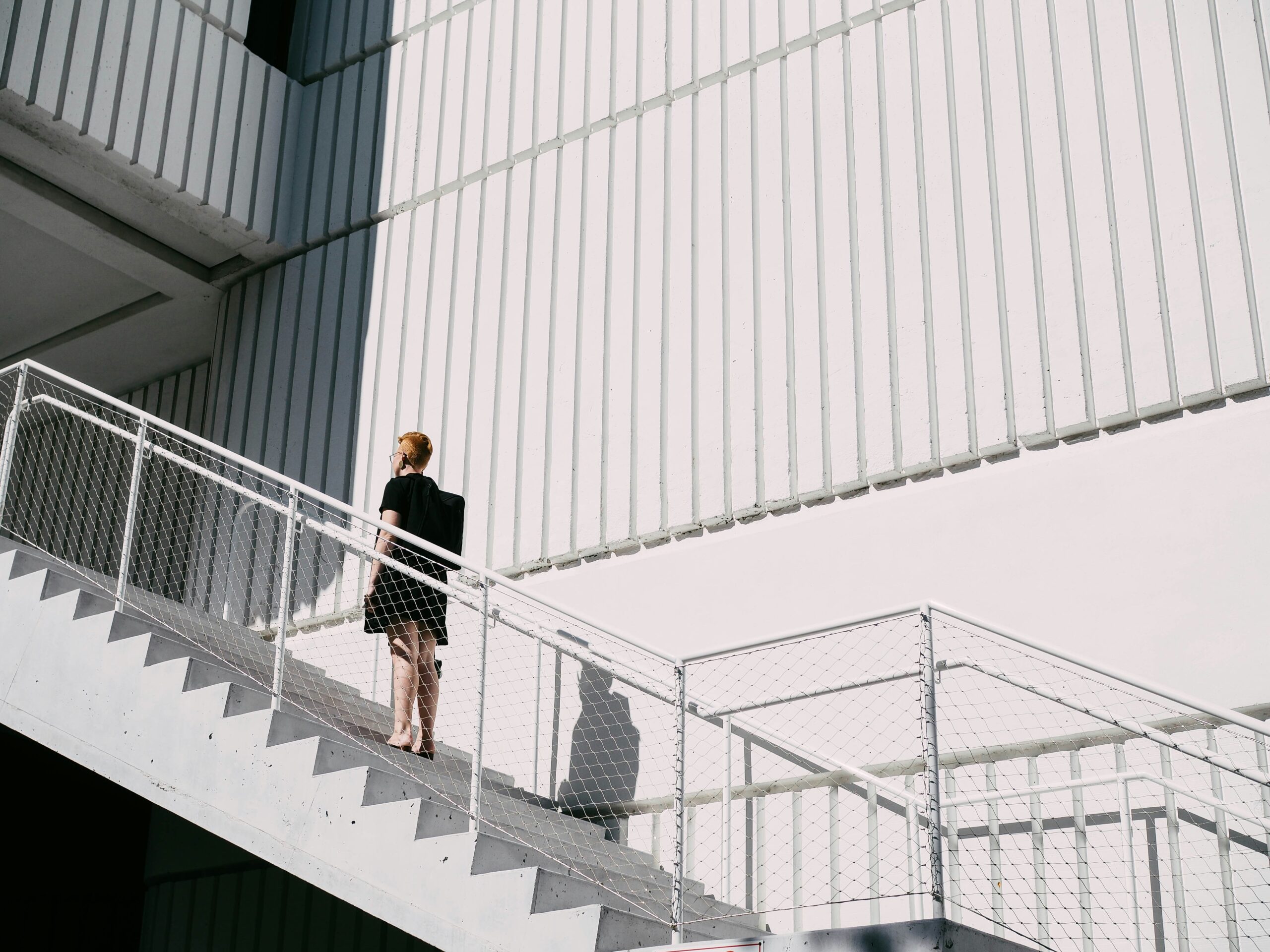 side view of white commercial building with man walking up the stairs.